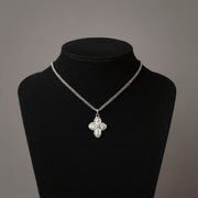 Silver necklace with a floral pendant on a black mannequin against a gray background