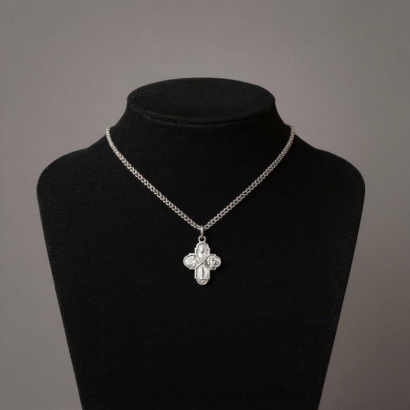 Silver necklace with a floral pendant on a black mannequin against a gray background