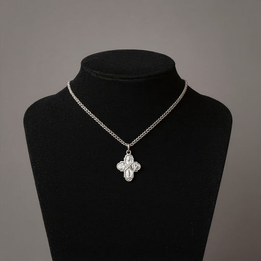 Silver necklace with a floral pendant on a black mannequin against a gray background