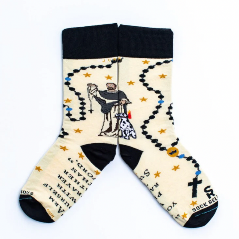 A pair of socks featuring a design with religious and mystical elements, including a figure of St. Dominic and symbols such as a torch and stars, on a white background.