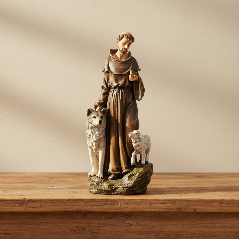 Statue of St. Francis of Assisi with a wolf and a lamb on a wooden surface
