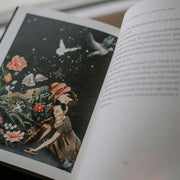 Open book with a colorful illustration of two people under a starry sky, surrounded by flowers and butterflies.
