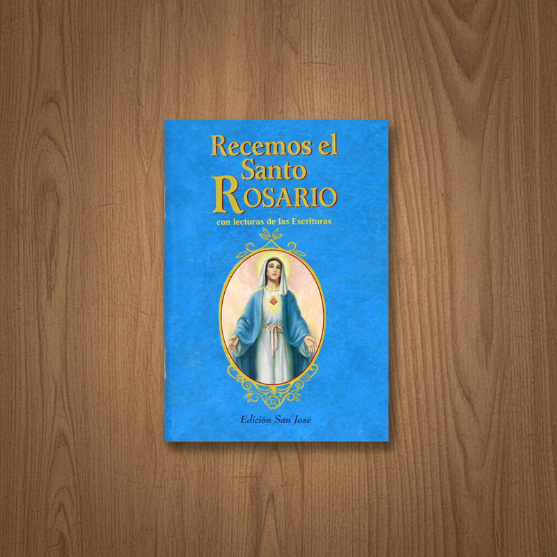 Blue book titled 'Recemos el Santo Rosario' on a wooden surface
