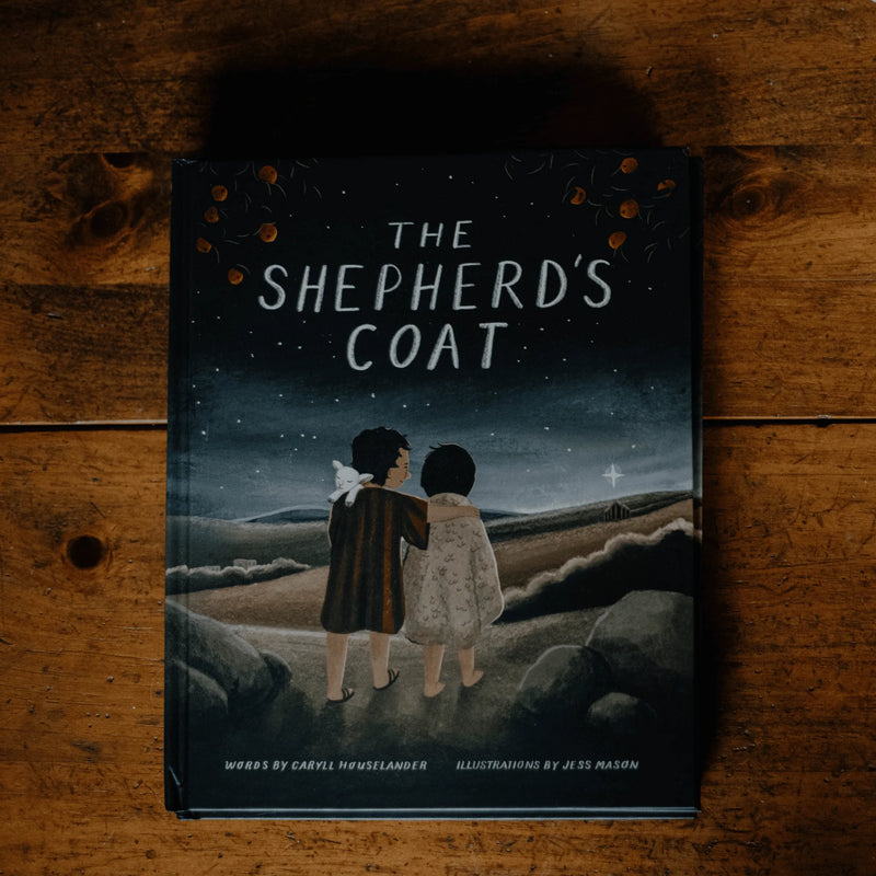 Book titled 'The Shepherd's Coat' on a wooden surface