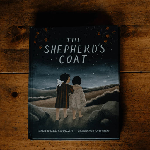 Book titled 'The Shepherd's Coat' on a wooden surface