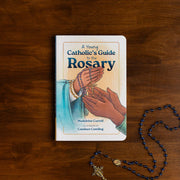 Book entitled 'A Young Catholic's Guide to the Rosary' on a dark wood surface