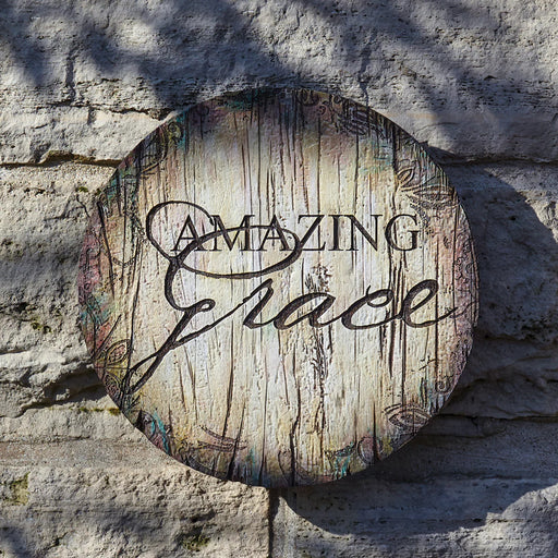 Round wooden sign with 'Amazing Grace' text on a stone wall