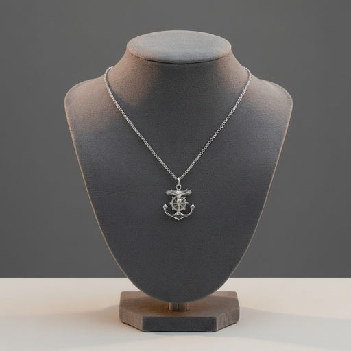 Silver necklace with an anchor pendant on a gray mannequin bust against a gray background