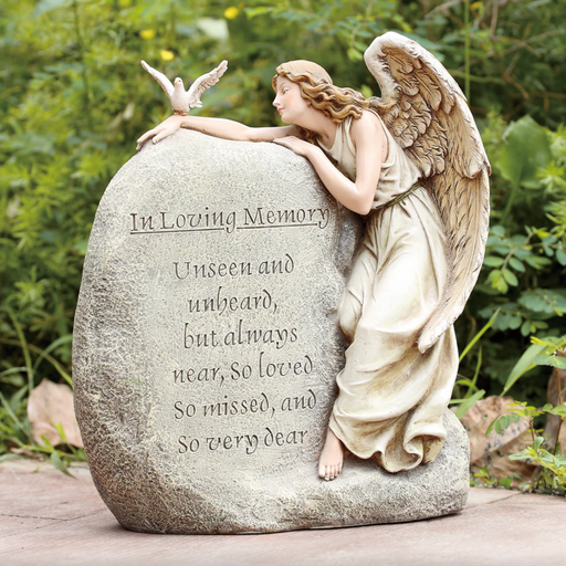 Memorial statue of an angel draped across a rock with text.