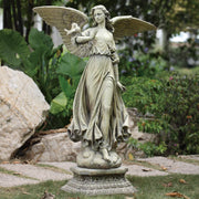 Statue of an angel holding a dove in a garden setting