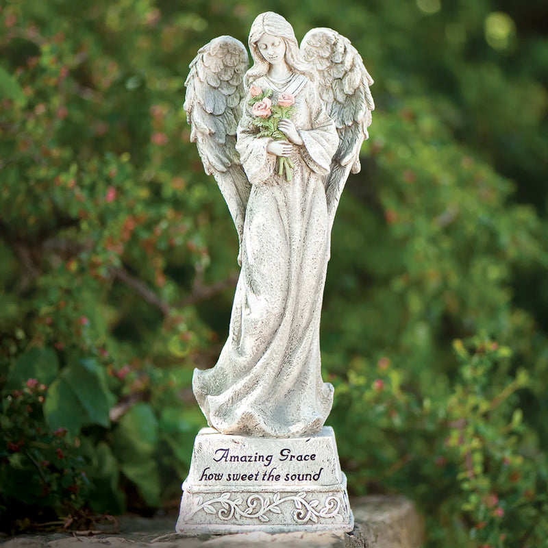 Statue of an angel holding flowers with a blurred green background