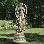 Statue of an angel in a garden setting with greenery
