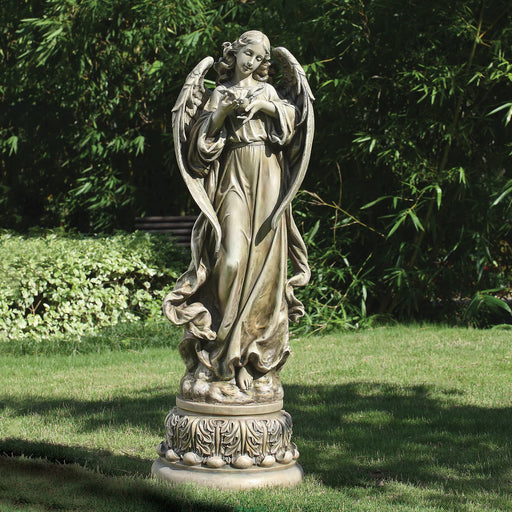 Statue of an angel in a garden setting with greenery