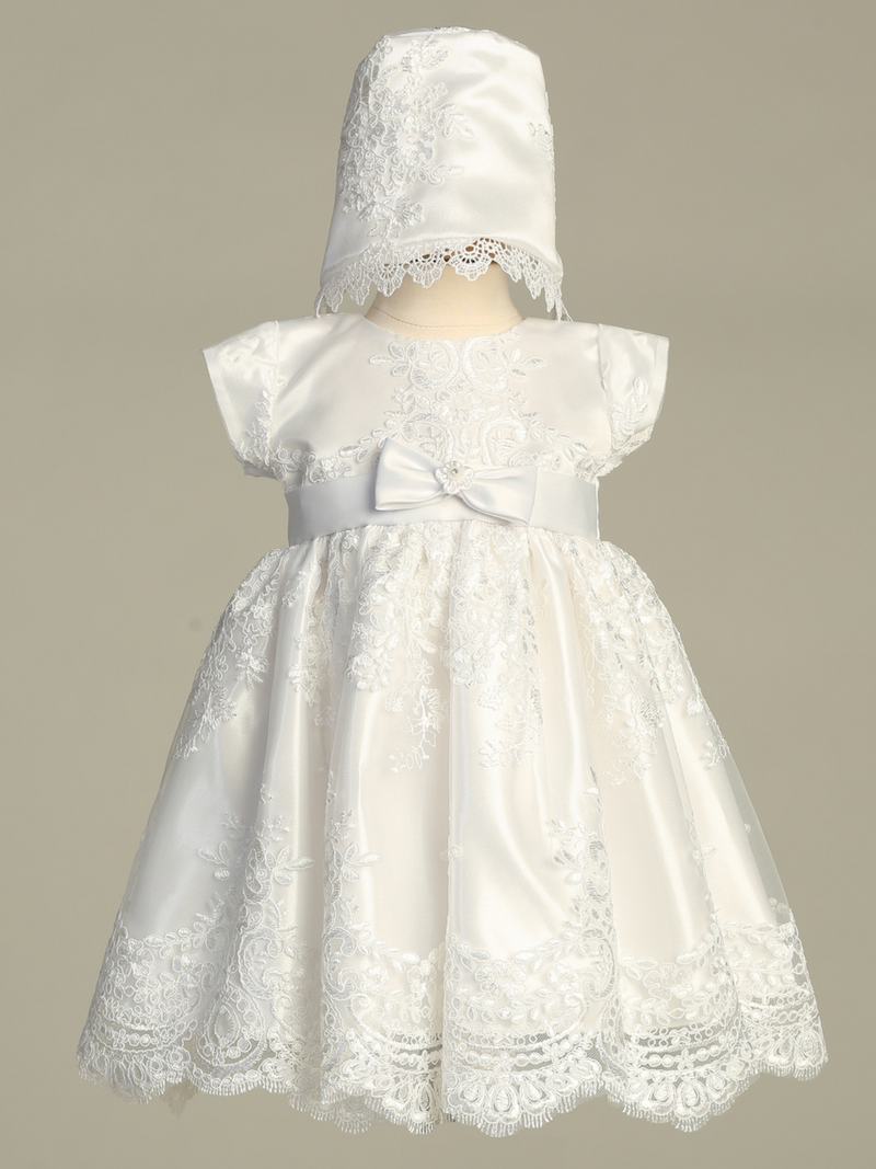 White lace baptism dress with matching bonnet on a mannequin against a gray background