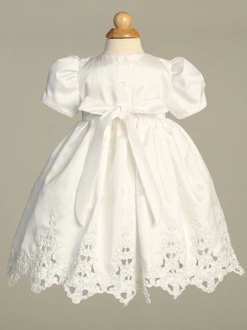 White lace dress on a mannequin against a gray background