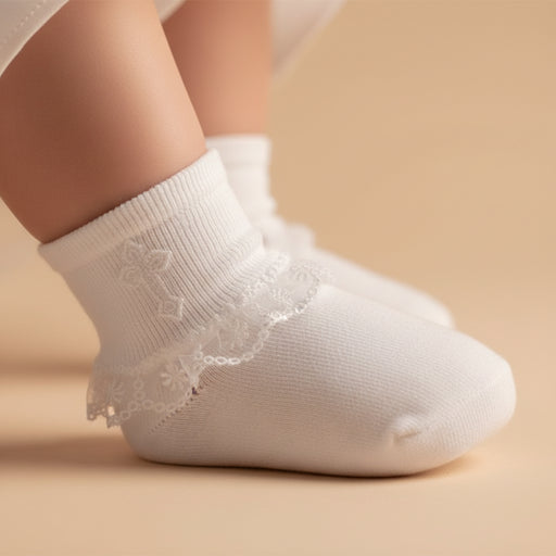 White baptismal sock with lace trim on a beige background