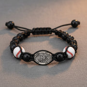 Bracelet with baseball beads and a central emblem on a textured surface