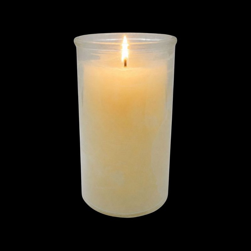 White candle in a clear glass holder on a black background