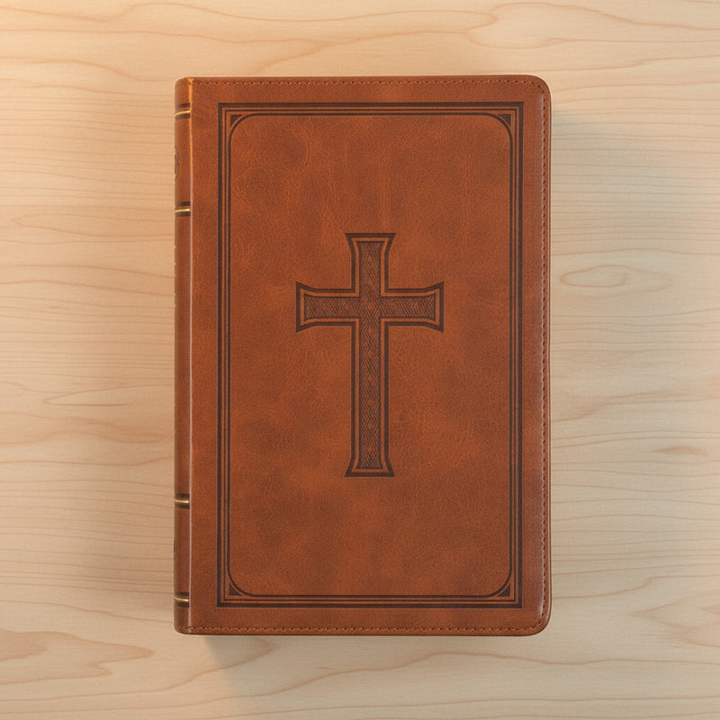 Brown leather Bible with a cross design on a wooden surface