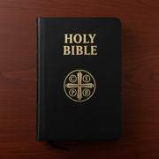 Black Bible with gold text and logo on a wooden surface