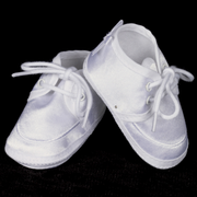 Pair of white baby shoes on a black background