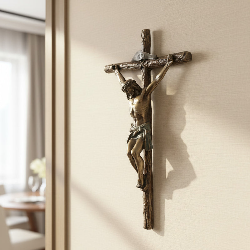 Bronze crucifix on a beige wall with a soft shadow