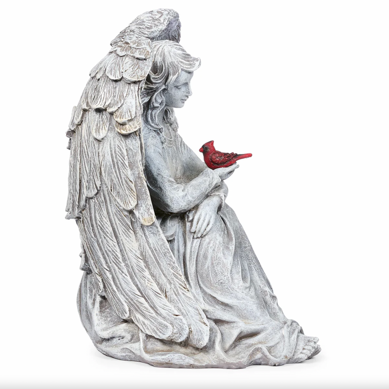 Statue of an angel holding a cardinal on a white background