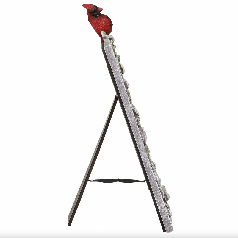 Cardinal bird perched on a memorial picture frame on a white background