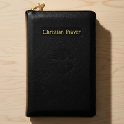 Black leather prayer book with 'Christian Prayer' on a wooden surface