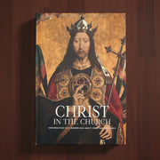 Book cover of 'Christ in the Church' with a religious illustration on a wooden background