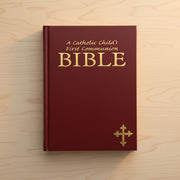 Red Bible for Catholic First Communion on a wooden surface
