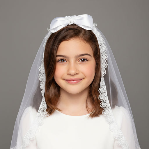 Young girl wearing a white Communion veil with a bow on a gray background