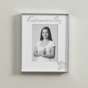 Framed black and white photo of a young girl with 'Confirmation Day' text on a light gray wall.