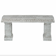 Decorative memorial stone bench with intricate carvings on a white background