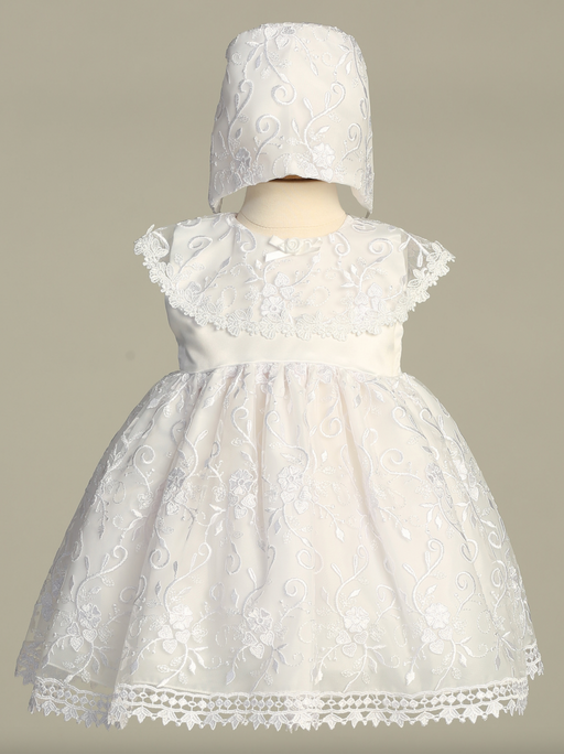 White lace baptism dress with matching bonnet on a neutral background
