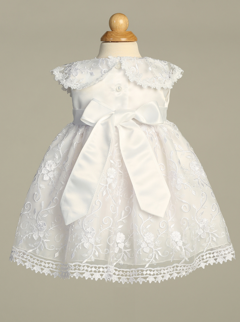White lace baptism dress on a mannequin against a gray background