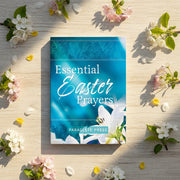Book titled 'Essential Easter Prayers' by Paraclete Press on a wooden surface with flowers around.