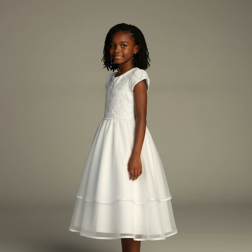 Young girl wearing a white communion dress against a plain background