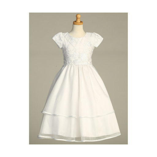 A white First Communion gown over a gray background.