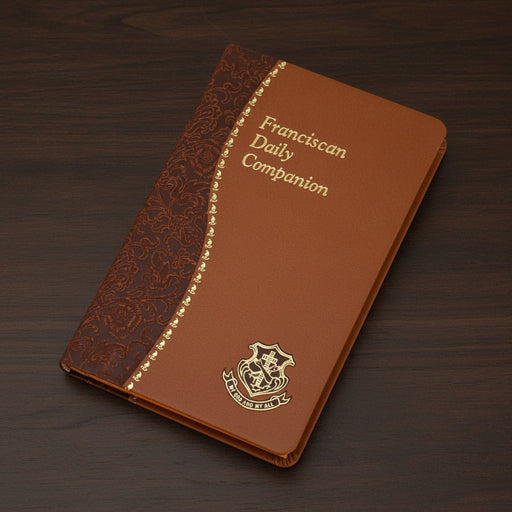Brown faux leather book titled 'Franciscan Daily Companion' on a wood surface