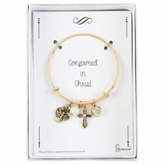 Gold Confirmation bracelet with charms on a branded card
