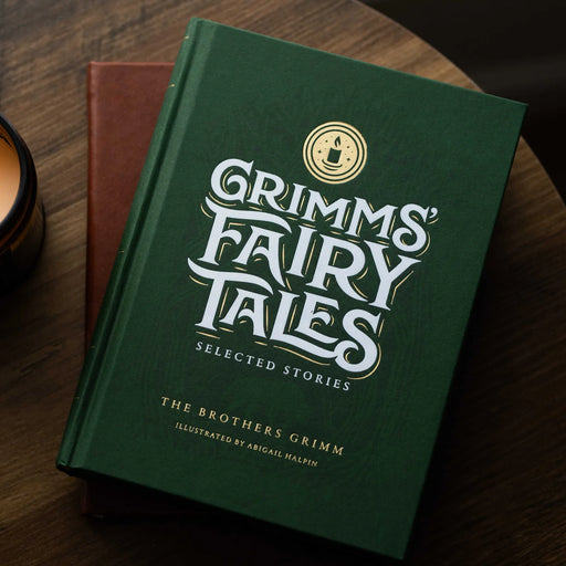 Dark green book titled 'Grimm's Fairy Tales' on a wood surface.
