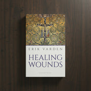 Book titled 'Healing Wounds' by Erik Varden on a wooden surface
