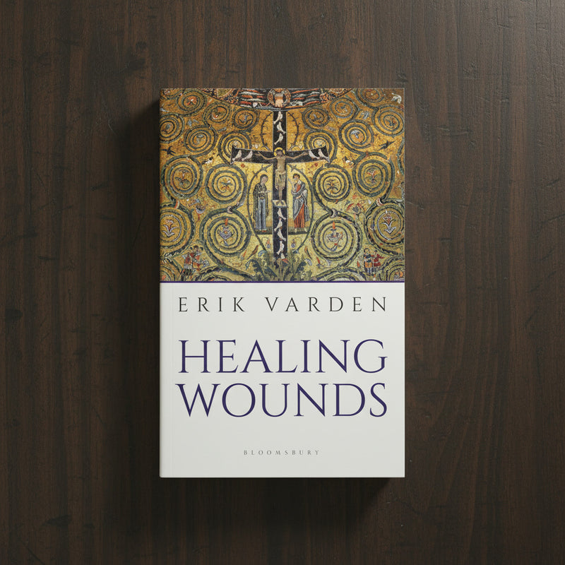 Book titled 'Healing Wounds' by Erik Varden on a wooden surface