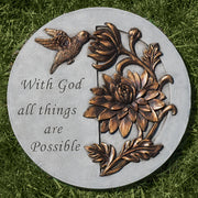 Decorative stone with floral design and 'With God all things are Possible' text on grass