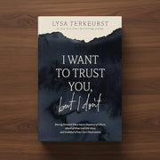 A navy blue book titled 'I Want to Trust You, But I Don't' on a dark wood surface