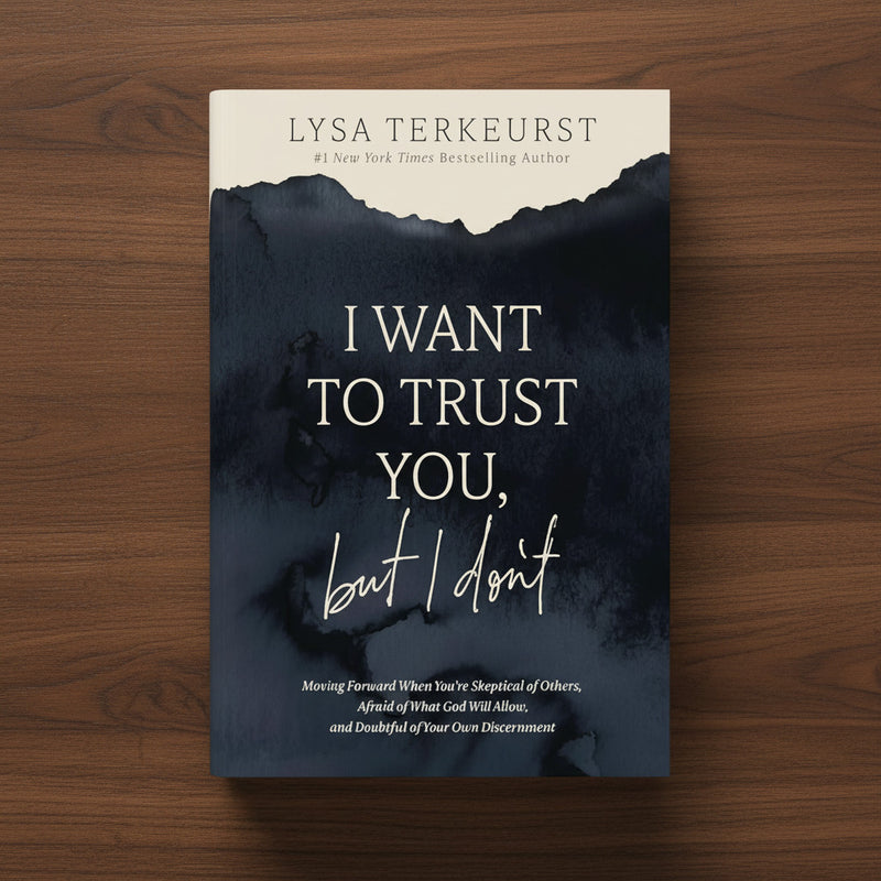 A navy blue book titled 'I Want to Trust You, But I Don't' on a dark wood surface