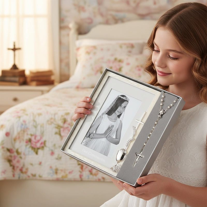 Young girl holding a boxed picture frame for a 4x6 inch photo and a rosary in a bedroom setting