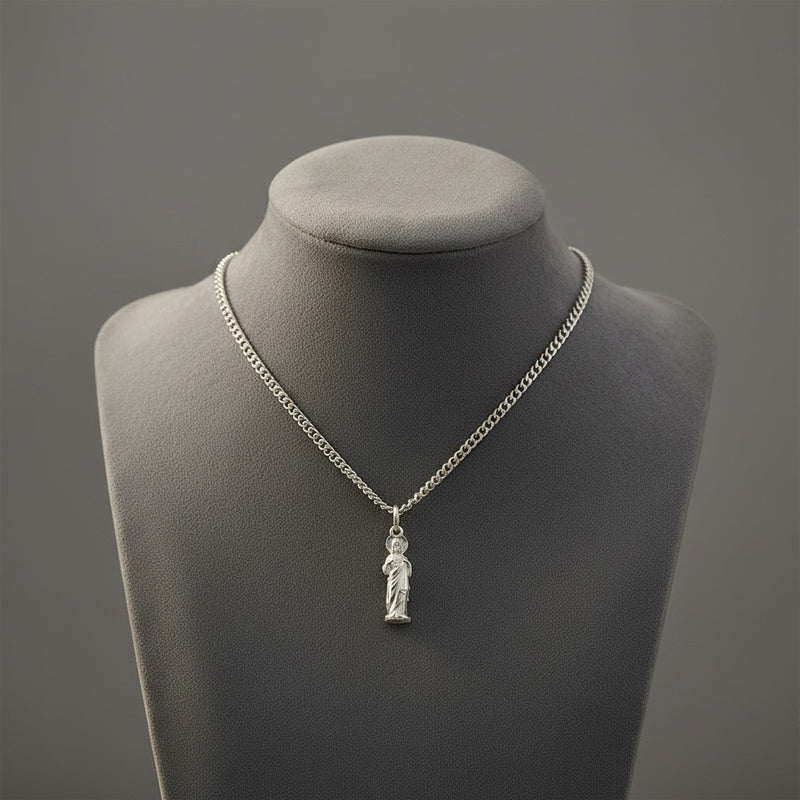 Silver necklace with a Sacred Heart of Jesus pendant on a gray mannequin bust against a gray background