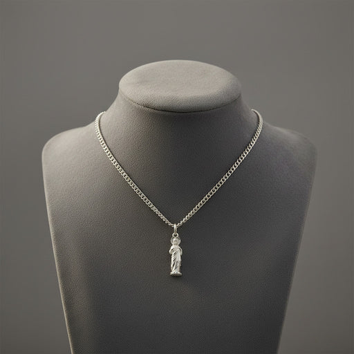 Silver necklace with a Sacred Heart of Jesus pendant on a gray mannequin bust against a gray background
